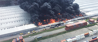 Large industrial fire with smoke plume